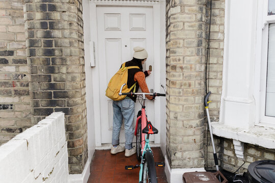 Cyclist arriving home with bicycle at doorstep