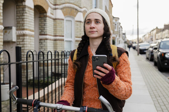 Commuter navigating city with smartphone and bicycle