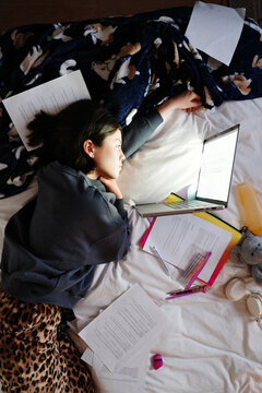 Person studying on bed preparing for exams