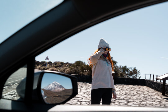 Woman photographing near car