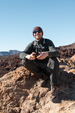 Man Sitting on Rocks in Volcanic Landscape During Sunny Day