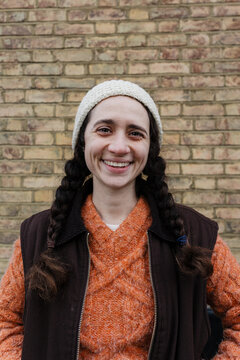 Smiling face expressing happiness against brick wall