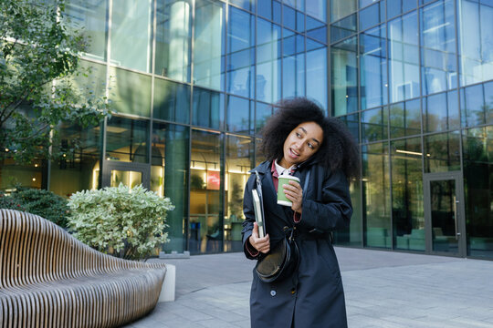 Black businesswoman talking on mobile phone near skyscraper building