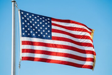 Fototapeta premium American flag waving on a pole under a clear blue sky