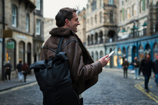 Man with backpack in city street
