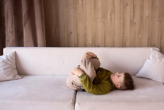 Child relaxing on a sofa in yoga pose