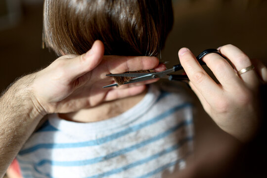 Father cutting little boy&rsquo;s hair at home