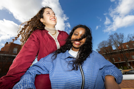 Two GenZ girl friends having fun in the street. Direct flash. UGC