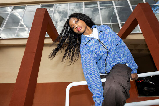 Portrait of young woman in urban outfit looking at camera 