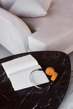 Notebook and headphones lie on a black table 