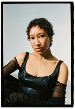 Model poses in a studio wearing a black outfit with short sleeve