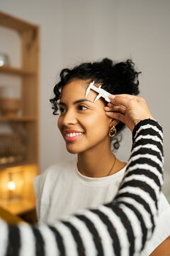 Woman getting microblading eyebrow measurement in beauty salon