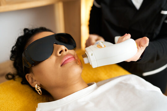 Woman receiving laser hair removal treatment in beauty salon