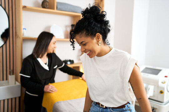 Client laughing with therapist preparing treatment bed