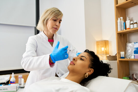 Doctor injecting filler into woman's forehead for rejuvenation