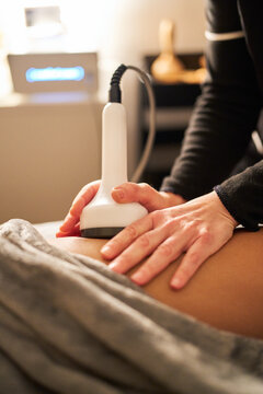 Therapist performing radio frequency body treatment on client