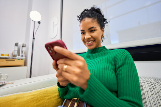 Young woman smiling using smartphone in beauty salon