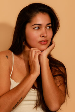 Woman With Long Hair Thinking and Posing Against Plain Background