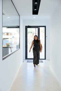 Businesswoman arriving office walking modern corridor smiling