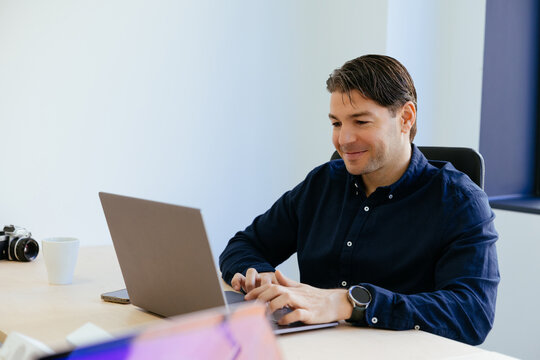 Man typing on laptop working in modern office