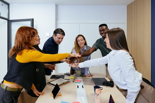 Diverse business team stacking hands for collaboration and success