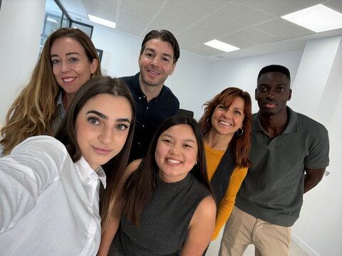 Diverse business team smiling posing for office selfie