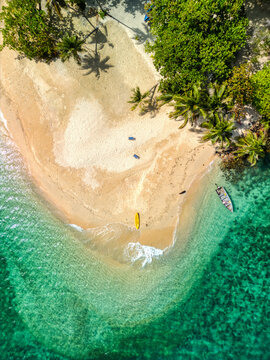 Aerial view of Ko Rayang Nok featuring a white sand beach, turquoise water, palm trees, and a yellow kayak on the shore in Ko Mak, Trat, Thailand.