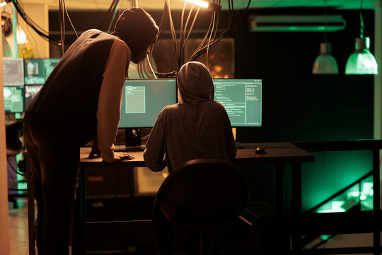 Hackers coding malicious software, cracking database password, online server illegal access, data breach. Cybercrime, internet thieves hacking computer network system at night time