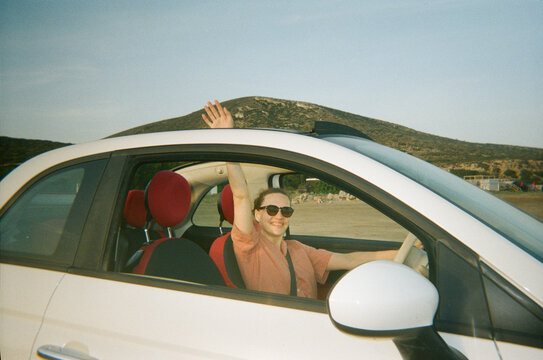 Woman Waves While Driving a Car in Rhodes, Greece