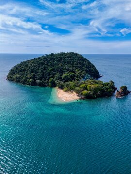Aerial view of Ko Rayang Nok island featuring a sandy beach, dense tropical forest, and turquoise sea in Ko Mak, Trat, Thailand.