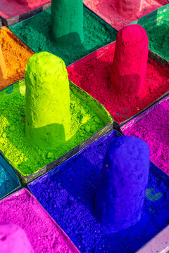 Vibrant powdered pigments in trays, colorful texture background