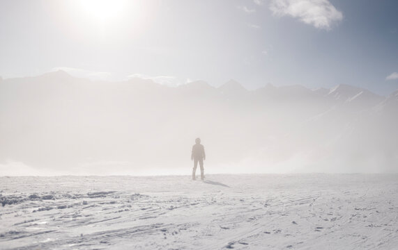 Young Skier silhouette Standing on surreal snowy mountain