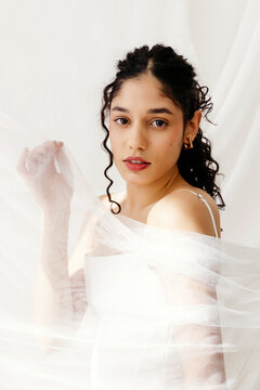 Woman portrait holding tulle bridal veil fabric