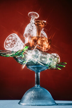Glass collection stacked on a table with a red background