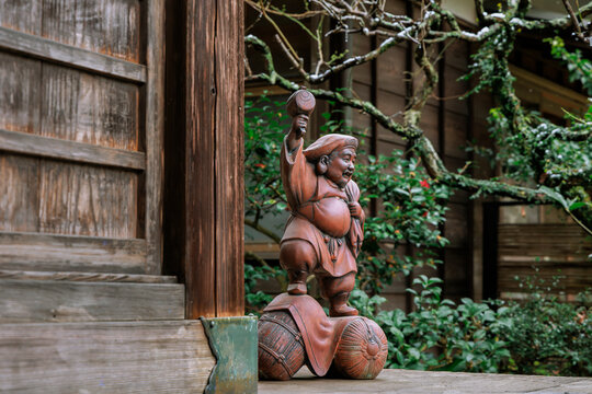 A Miniature Statue of a Japanese Fortune God in a Temple Corner.