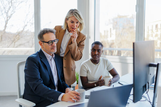 Business colleagues collaborating on project in office