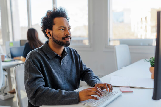 Professional man typing on computer in modern office