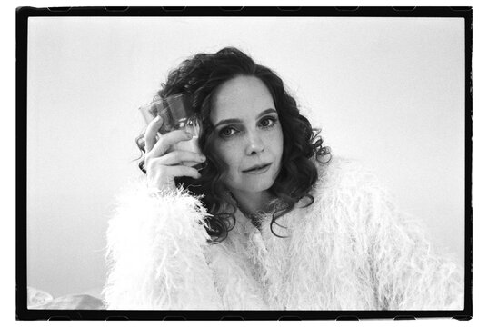 Woman holding a glass in a cozy setting indoors