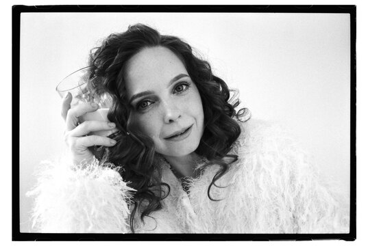 Woman holding a glass in a cozy setting indoors