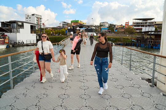 Women and child walking on floating bridge enjoying day
