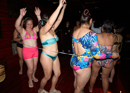 Women dancing at night pool party