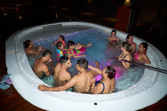 Group relaxing in hot tub at night