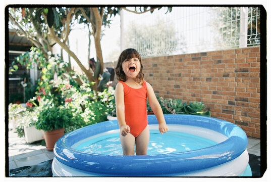 Happy child standing in inflatable backyard pool
