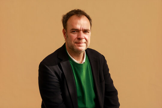  Man Sitting at a Table With a Plain Background