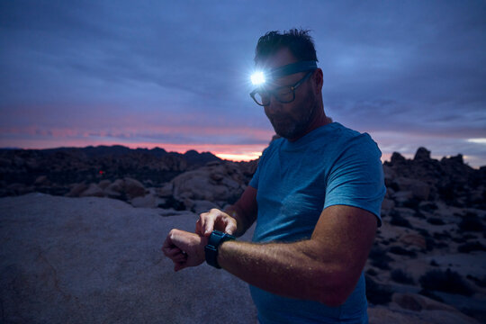 Man glances at his watch during a workout in the desert.