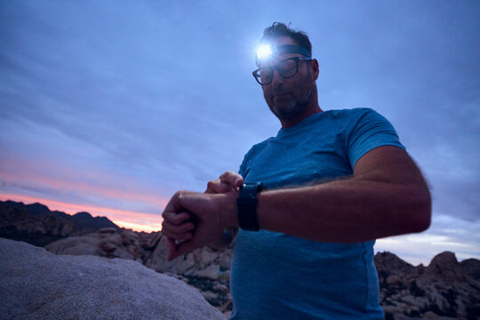Man checks his watch while exercising in the desert