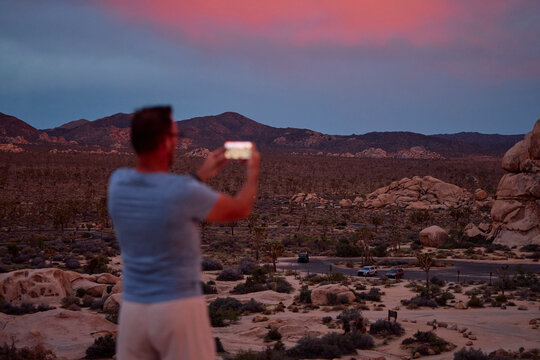 Man Photographs Desert Scene at Dusk