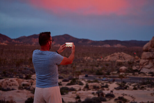 Man Captures Desert Landscape at Dusk