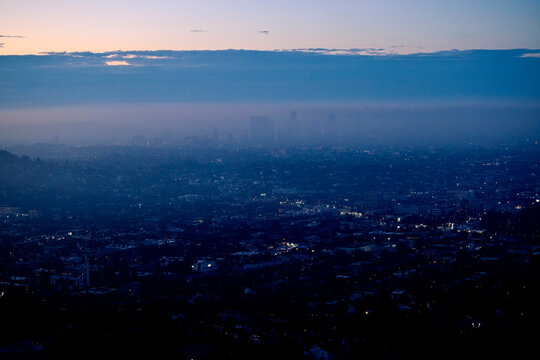 Los Angeles skyline at twilight, enveloped in mist and fog.