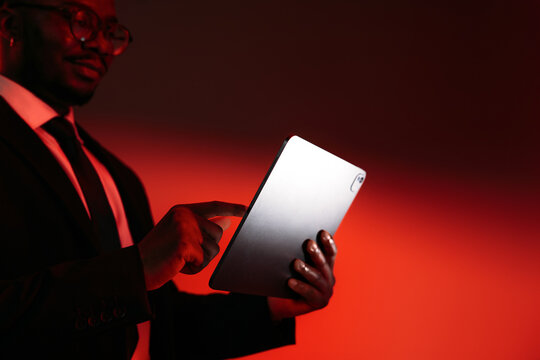 Business Professional Using Tablet With Dramatic Red Lighting